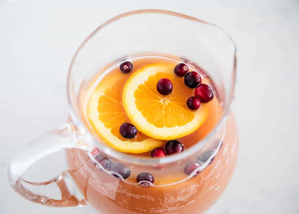 Christmas punch in a glass pitcher with cranberries.