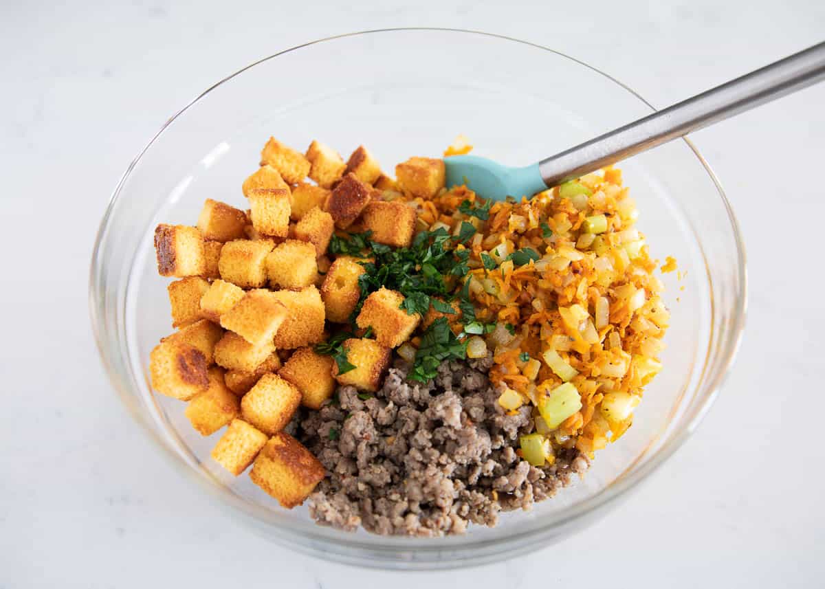 Cornbread stuffing ingredients in a glass bowl.