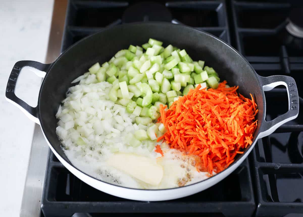 Carrots and celery cooking in a skillet.