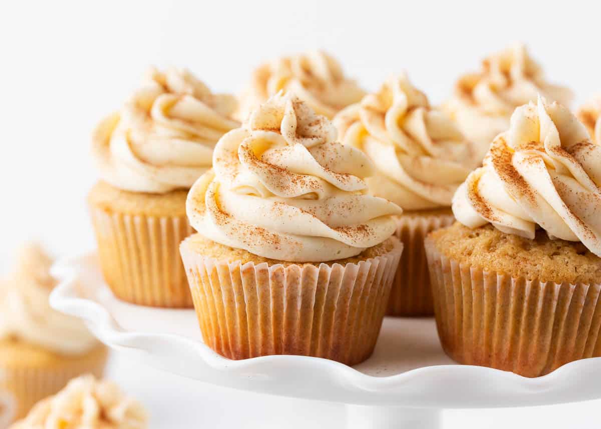 Eggnog cupcakes on a white cake platter.