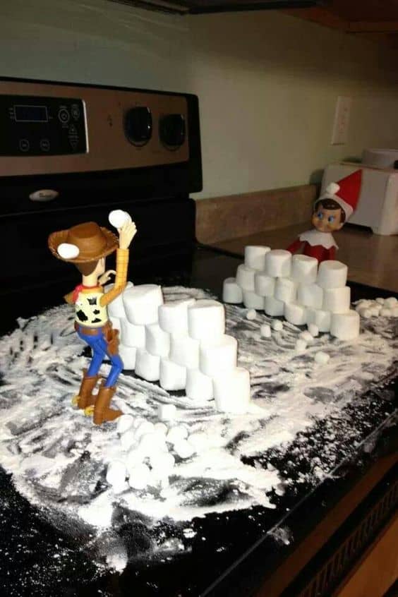 Elf and woody having a snowball fight with marshmallows.