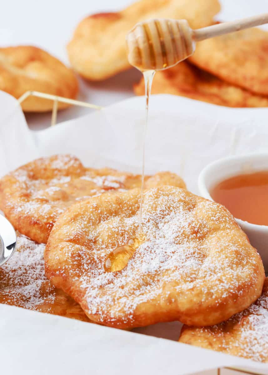 Drizzling honey over fry bread.