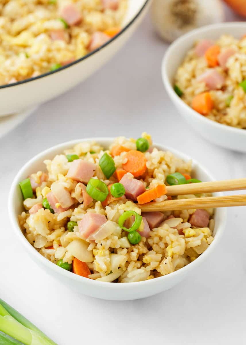 Ham fried recipe in a white bowl with chopsticks. 