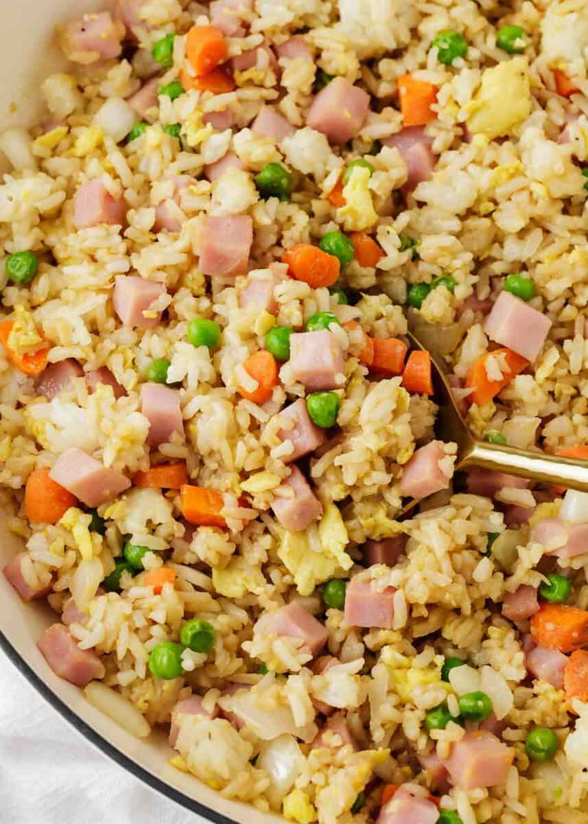 Ham fried rice being spooned out of a dish.