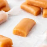 Caramel being wrapped in wax paper.