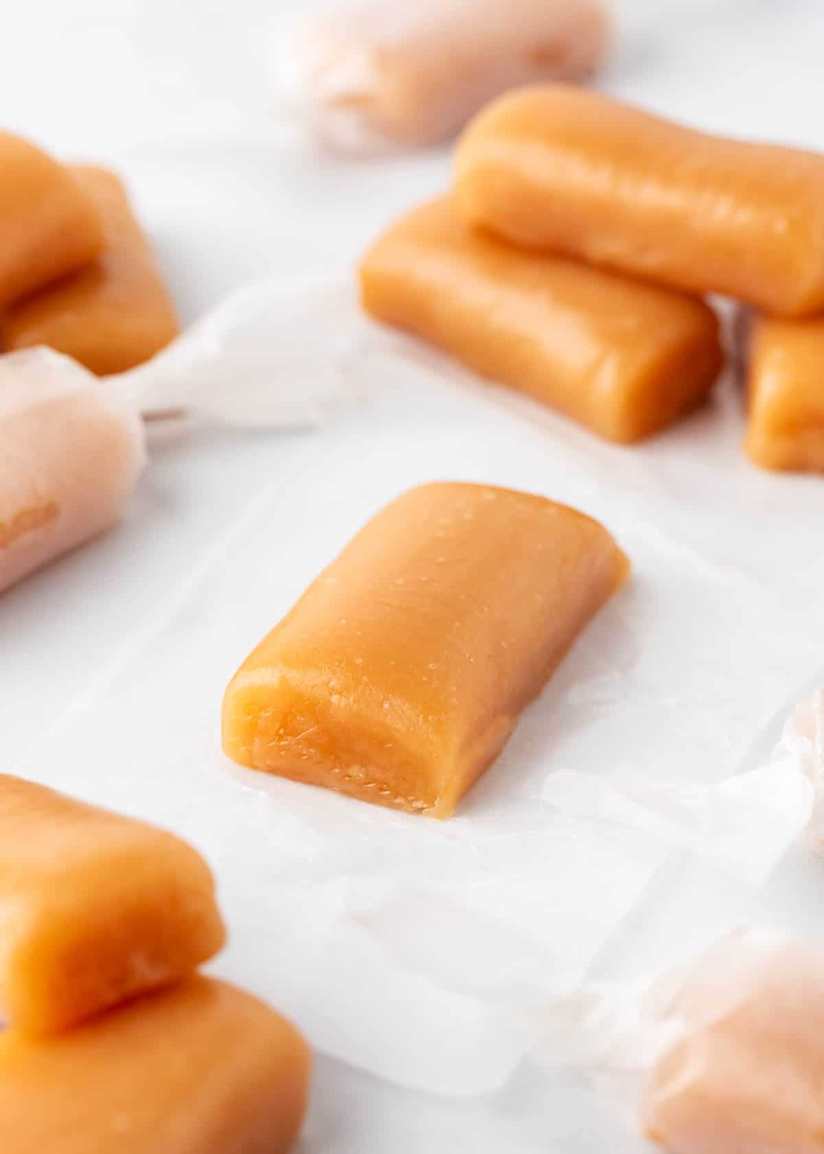 Caramel being wrapped in wax paper.