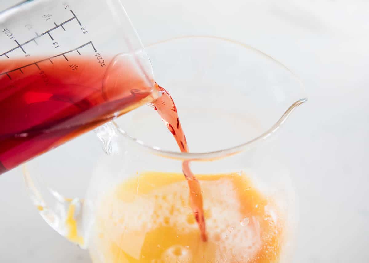 Pouring cranberry juice in a jar.