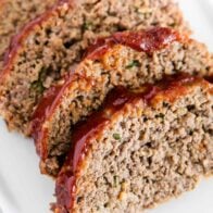 Sliced meatloaf on a white plate.