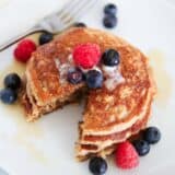 Cut oatmeal pancakes on a white plate with berries.