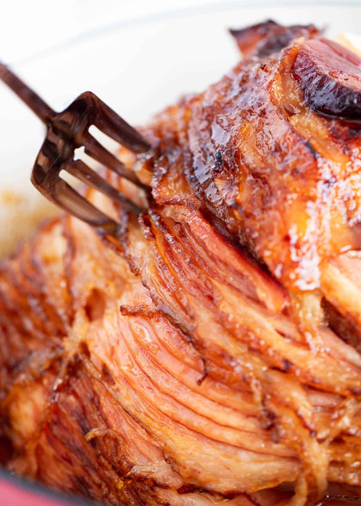 Baked ham on a white plate with a fork. 