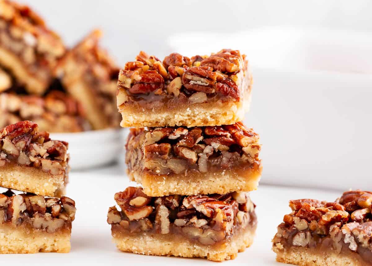 Stacked pecan pie bars on a countertop.