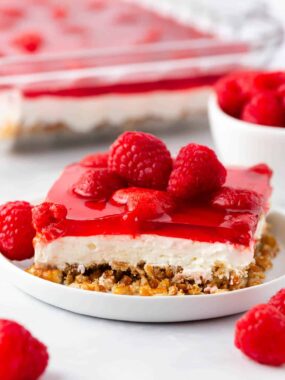 Slice of raspberry pretzel salad on a white plate.