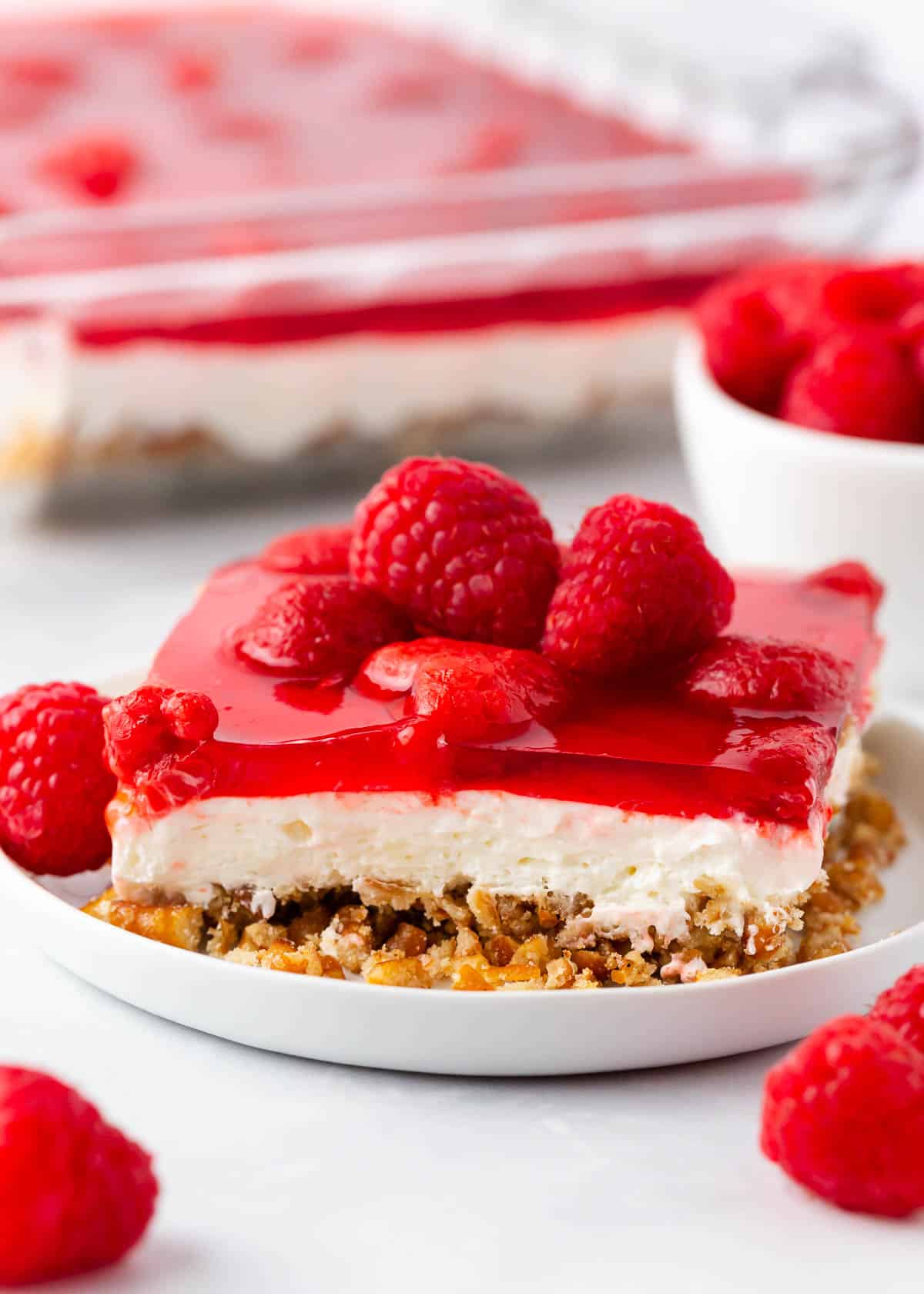 Slice of raspberry pretzel salad on a white plate.