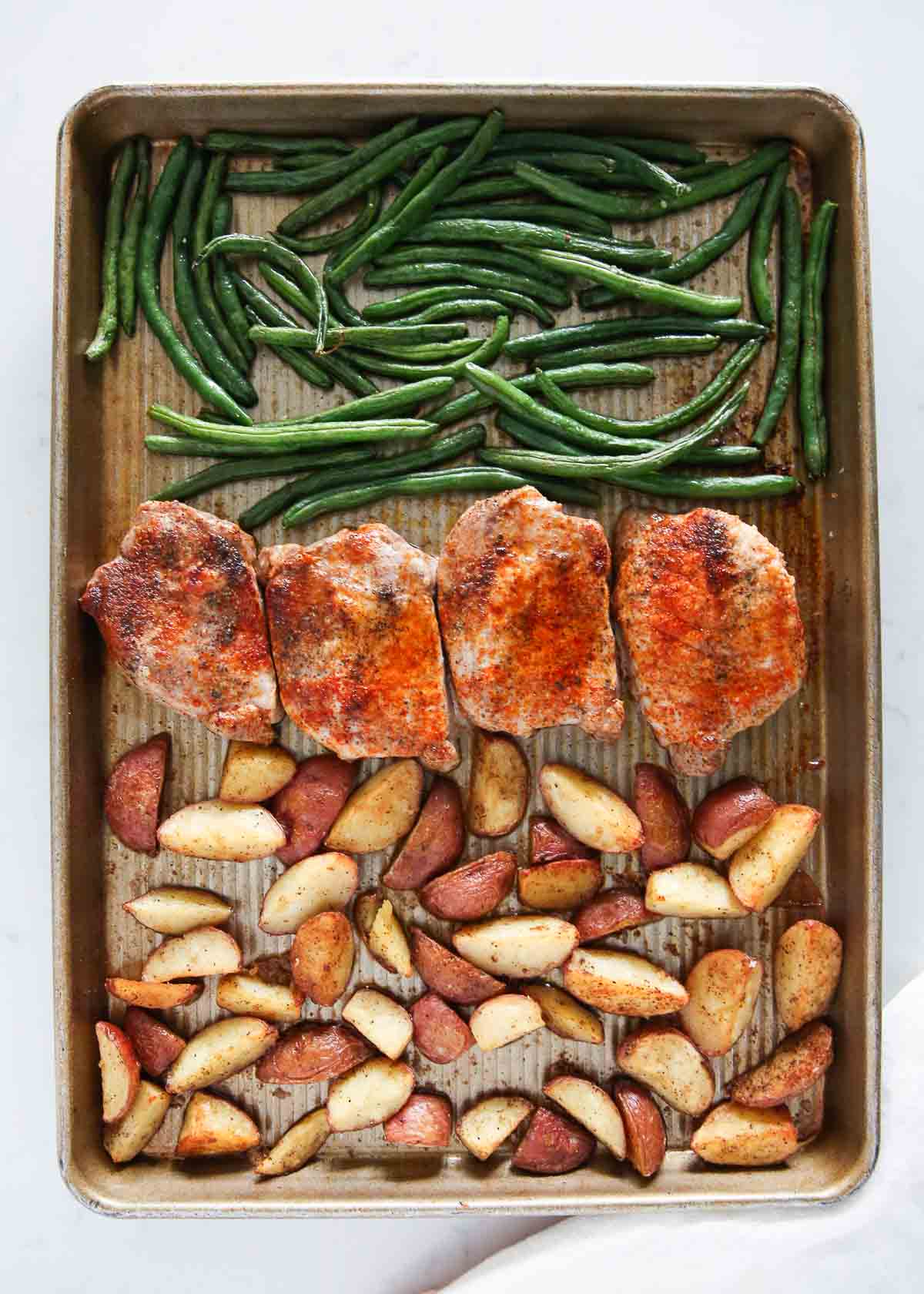 Sheet pan pork chops with potatoes and green beans.