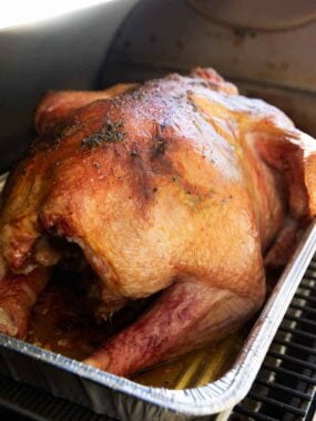 Smoked turkey in a metal pan.