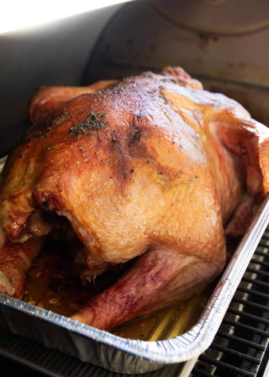 Smoked turkey in a metal pan.