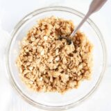 Streusel topping in a glass bowl with a spoon.