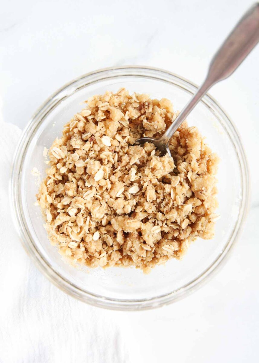 Streusel topping in a glass bowl with a spoon.