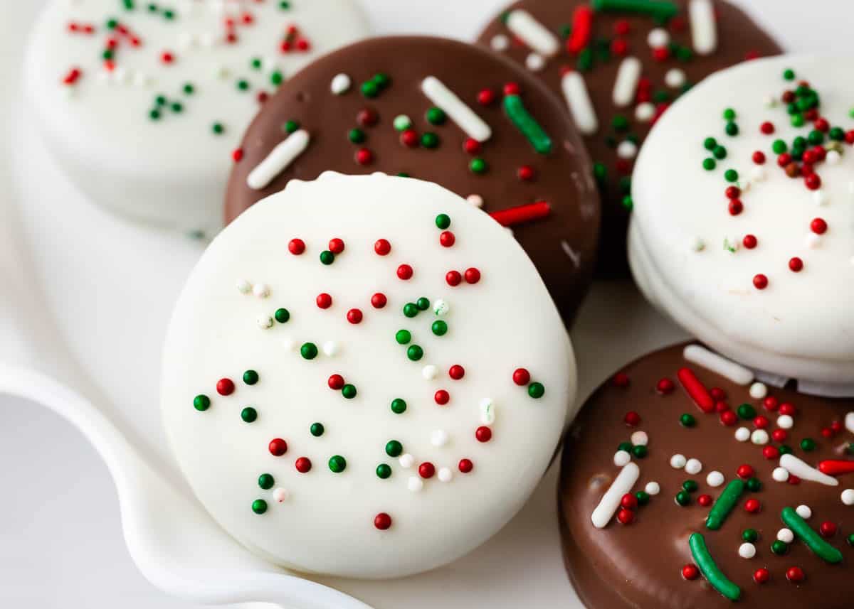 White chocolate covered oreos with sprinkles on top.