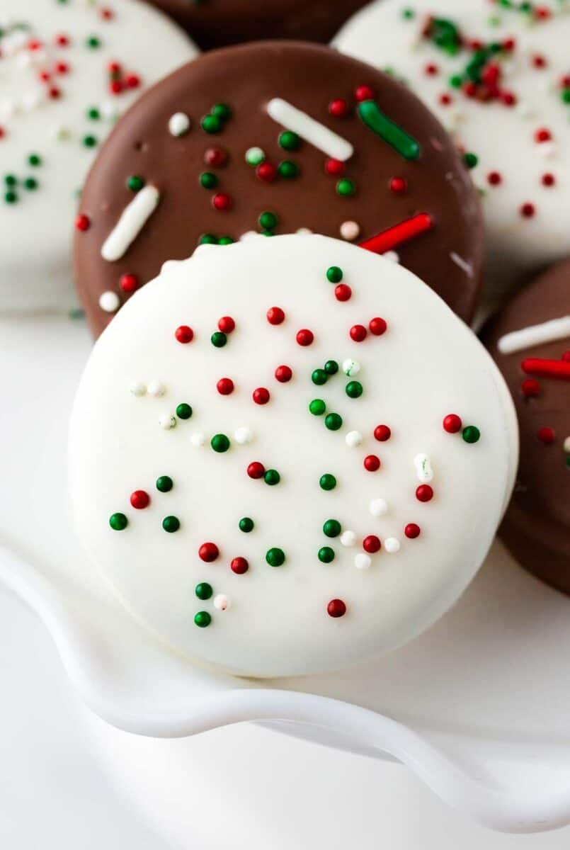 White chocolate covered oreos with sprinkles on top.