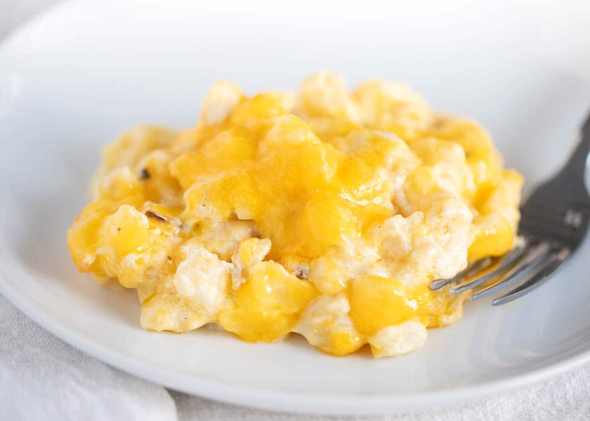 Cheesy potatoes on a white plate. 