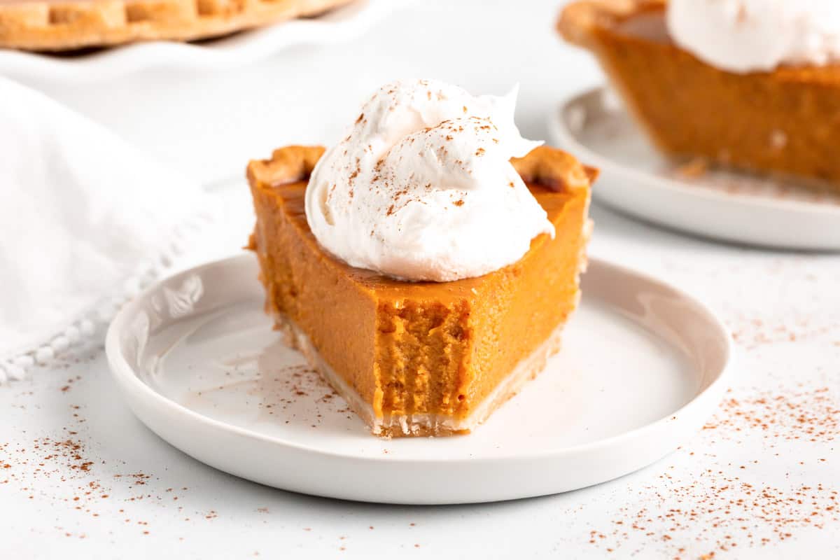 A slice of pumpkin pie with a bite out of it. 