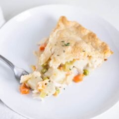 Slice of turkey pot pie made from scratch with leftover turkey on a white plate.