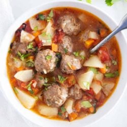 Albondigas soup in a white bowl.