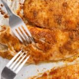 Baked tilapia on a baking pan with two forks.