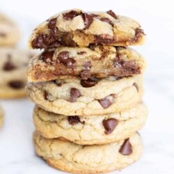 Chocolate chip cookies stacked on a counter.