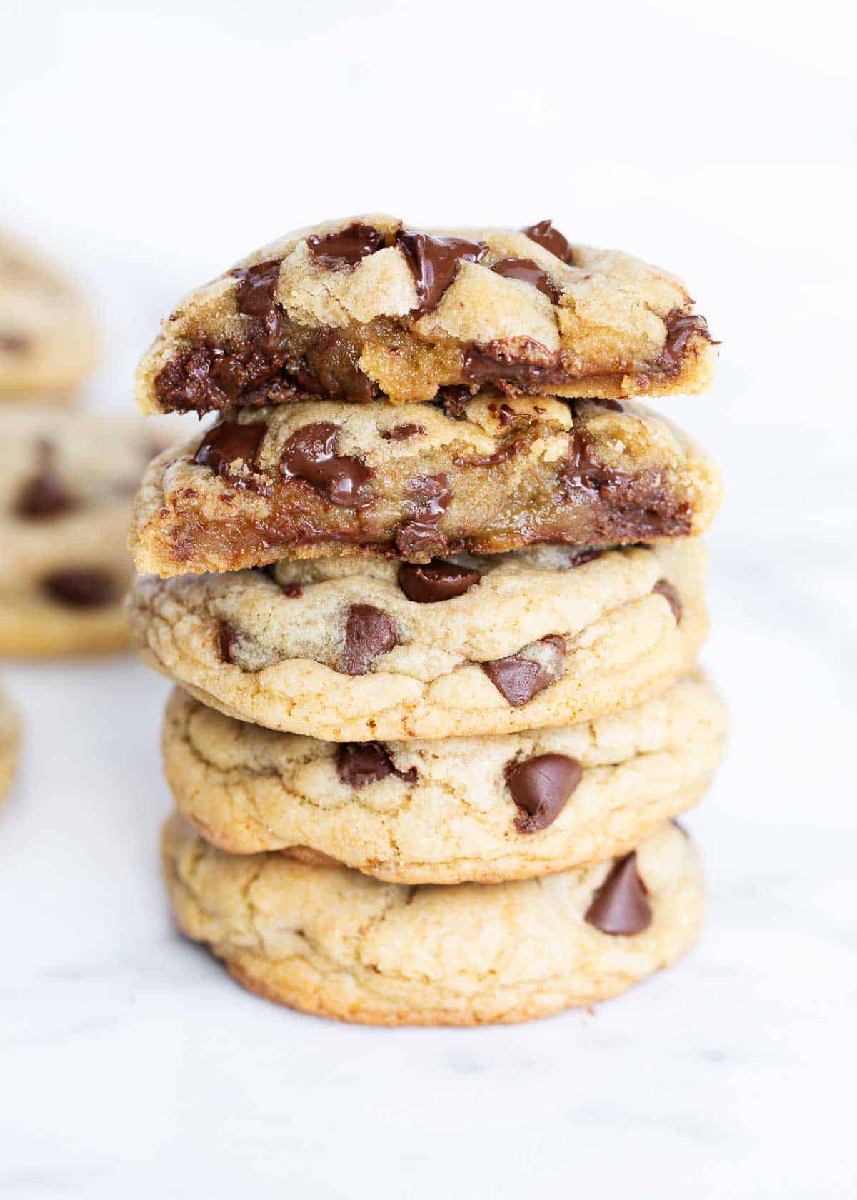 Chocolate chip cookies stacked on a counter.