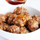 Pouring maple syrup on breakfast meatballs.