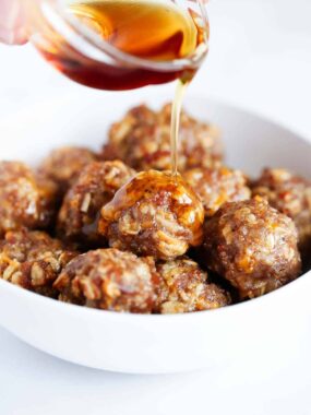 Pouring maple syrup on breakfast meatballs.
