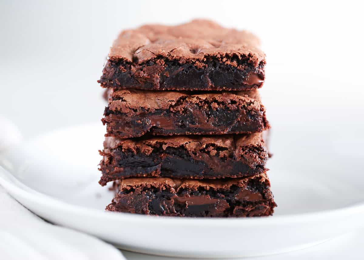 Brownies stacked on a white plate.