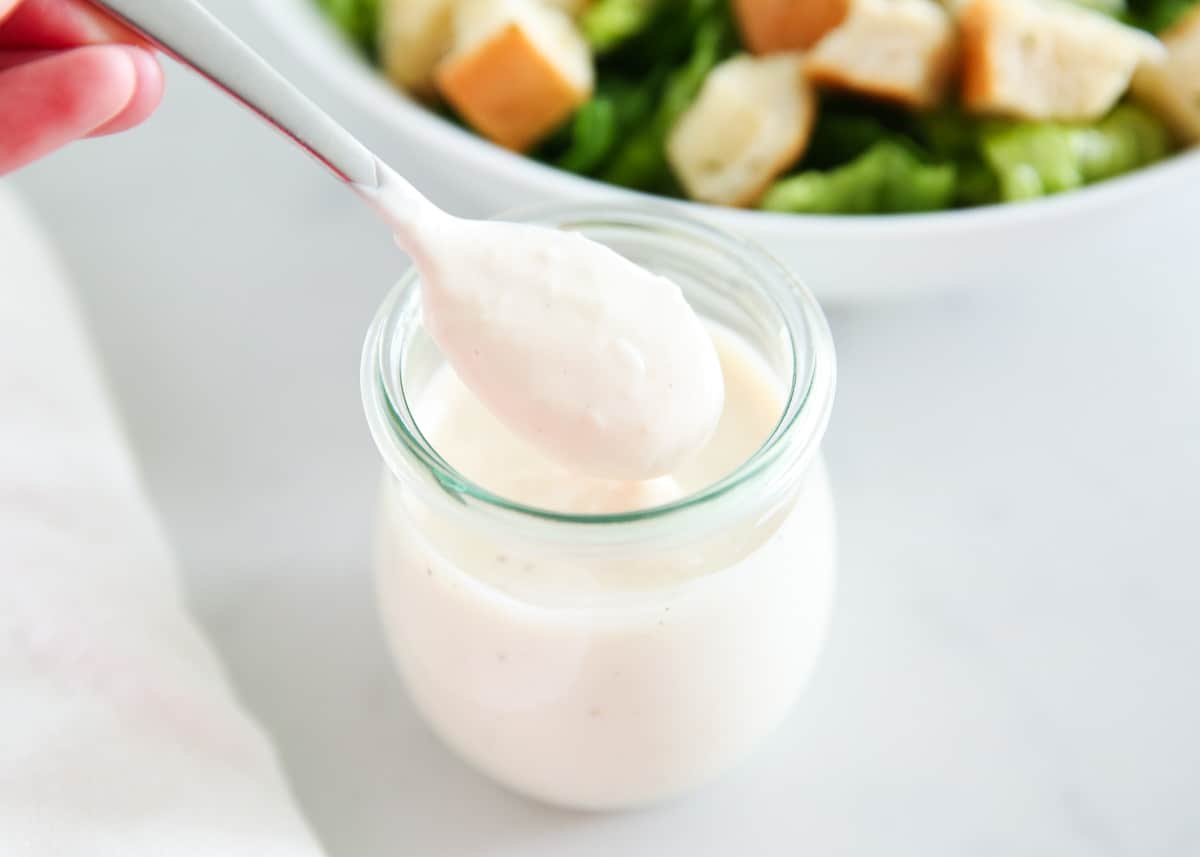 Caesar salad dressing in a glass jar.