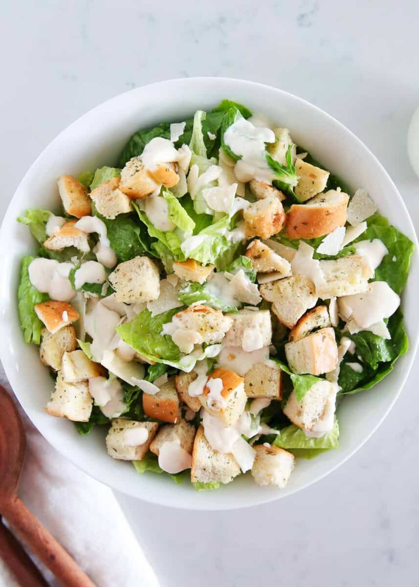Caesar salad in a white bowl with croutons.