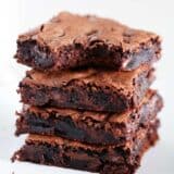 Stack of brownies on a white plate.