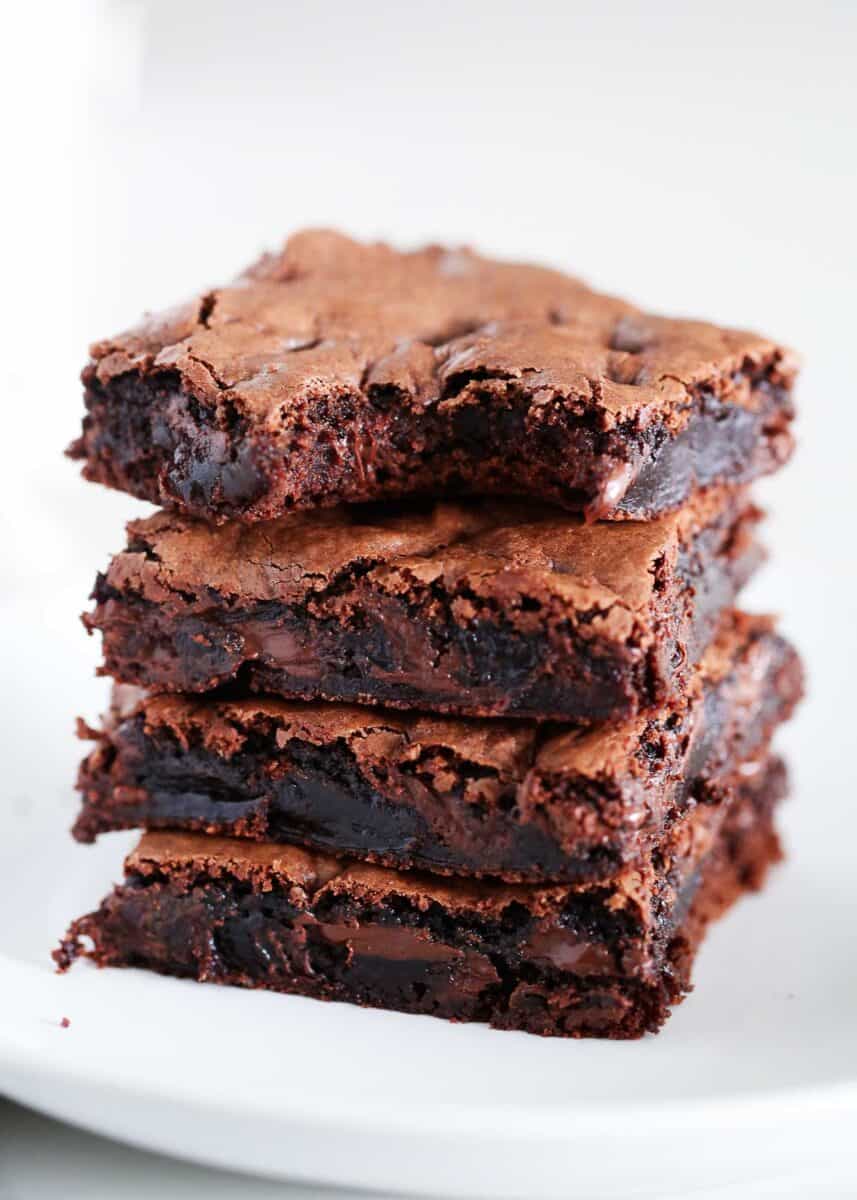 Stack of brownies on a white plate.