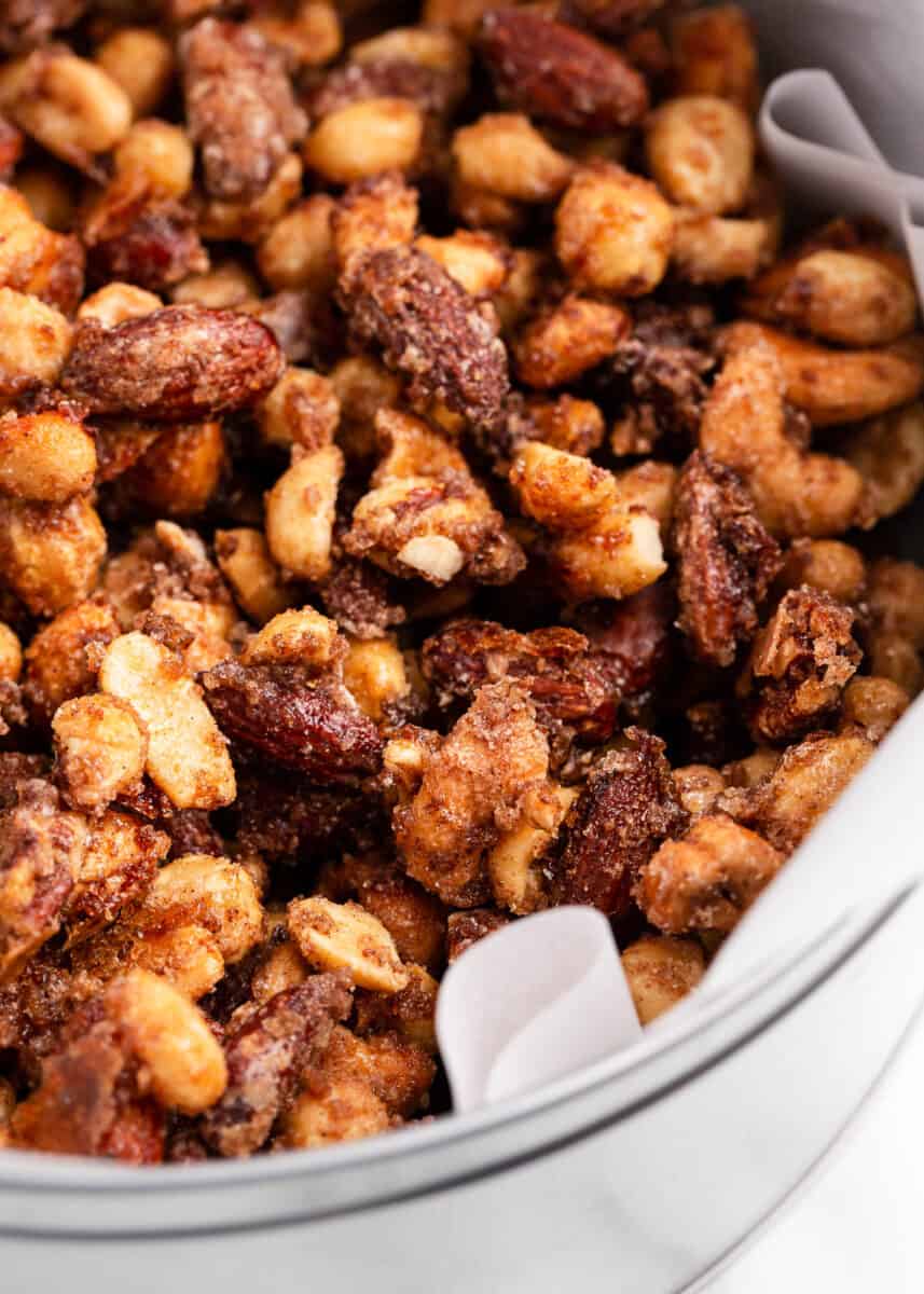 Candied nuts in a metal container with parchment paper.