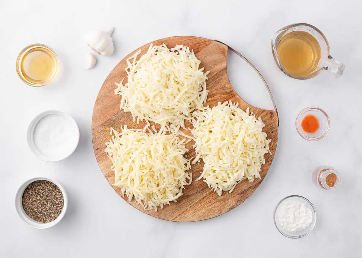 Cheese fondue ingredients on a marble counter.