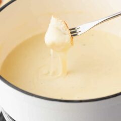 Cheese fondue and bread on a fork.