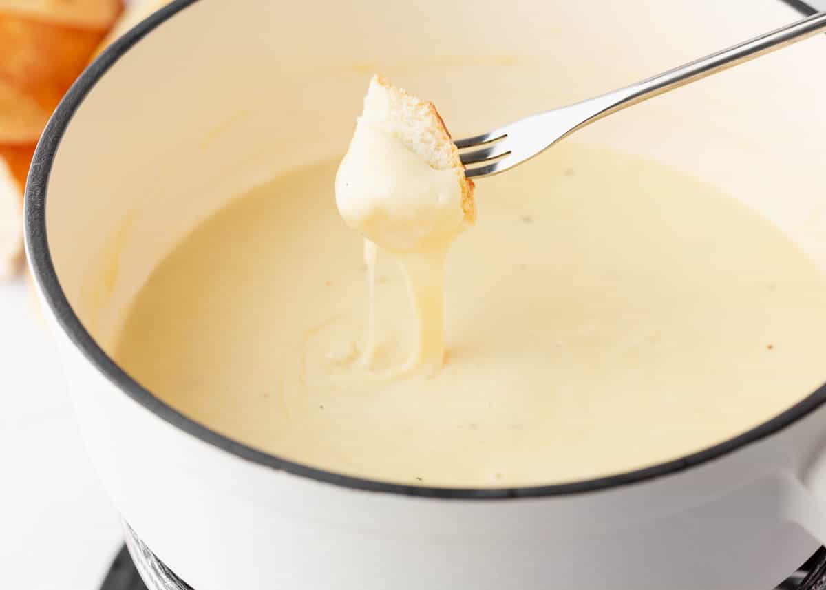 Cheese fondue and bread on a fork.