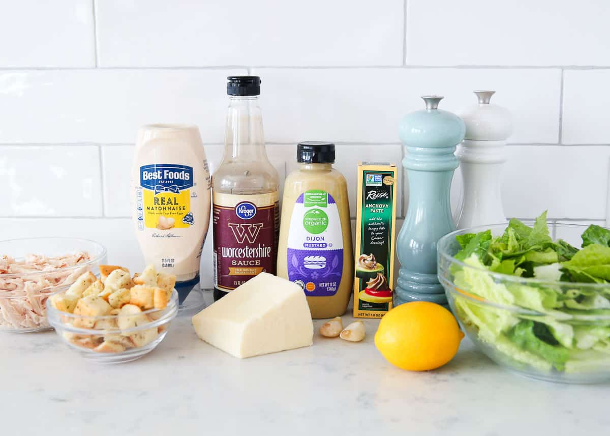 Chicken caesar salad ingredients on a marble counter.