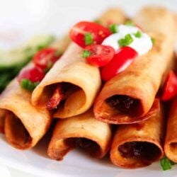 Chicken flautas on a white plate.