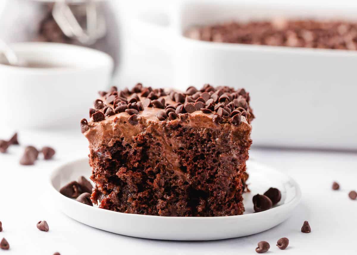 Chocolate poke cake on a white plate.