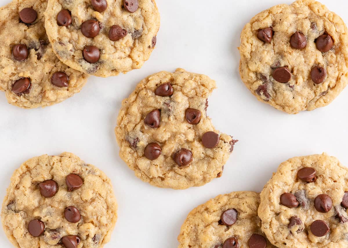 Oatmeal chocolate chip cookies with crisp edges and soft centers, with one cookie showing a bite.