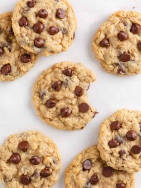 Soft and chewy oatmeal chocolate chip cookies with melty chocolate chips on a parchment-lined surface.