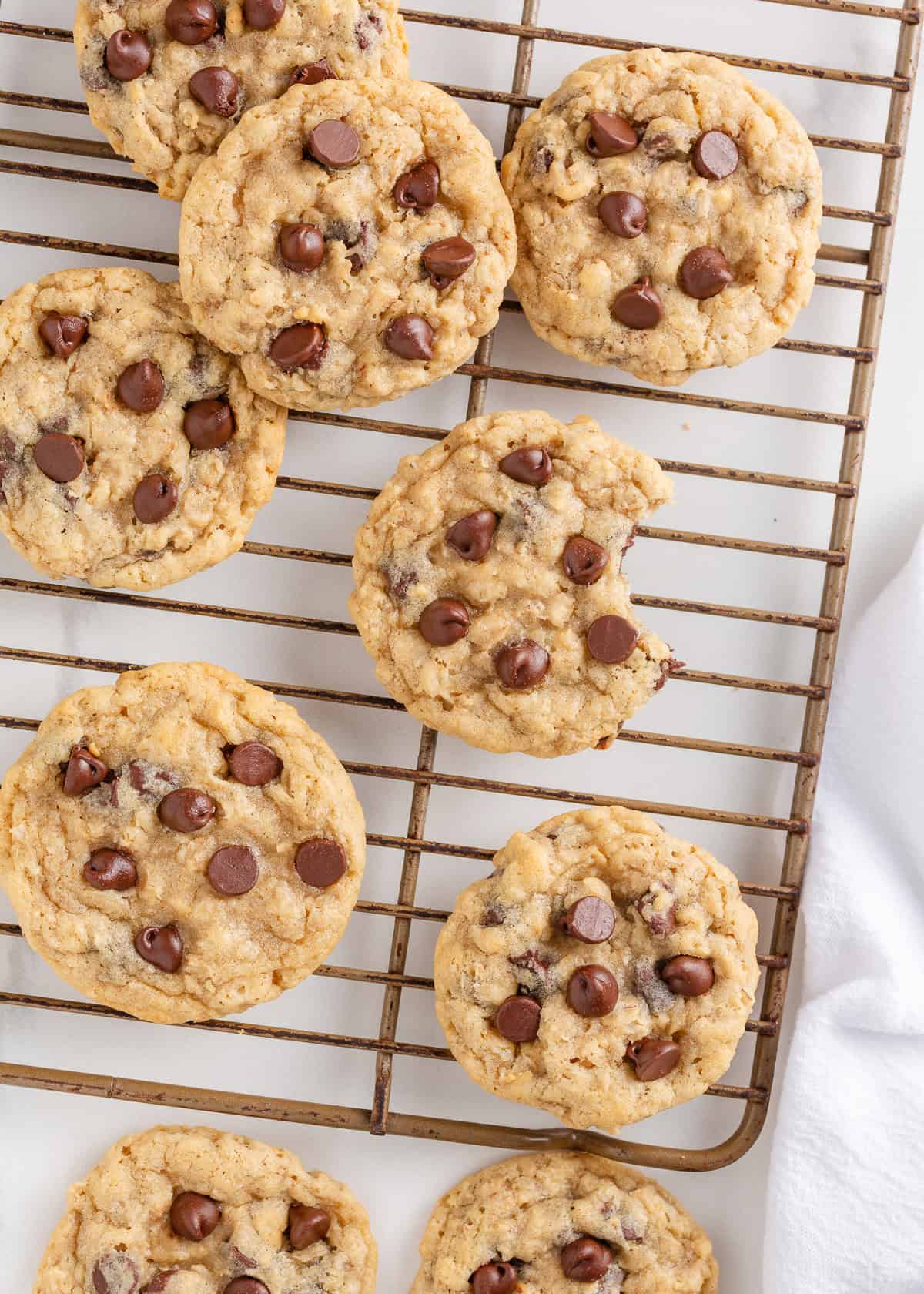 These easy oatmeal chocolate chip cookies bake up with soft centers, crisp edges and melty chocolate in every bite. A quick, one bowl cookie recipe everyone loves. Freshly baked oatmeal chocolate chip cookies cooling on a wire rack.