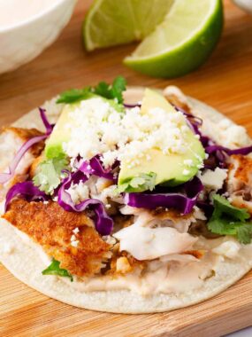 Fish tacos on a wooden board.