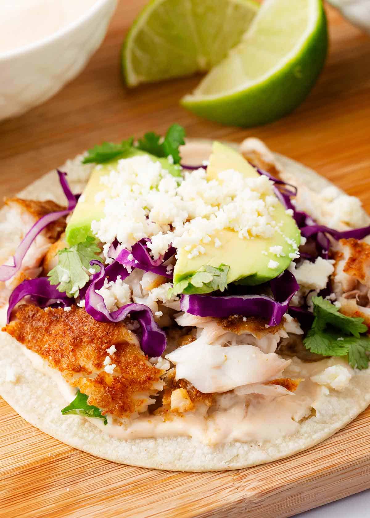 Fish tacos on a wooden board.
